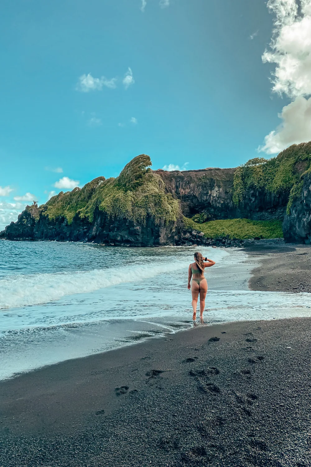 The black sand beach at Waianapanapa on the Road to Hana, turquoise water against dark sand