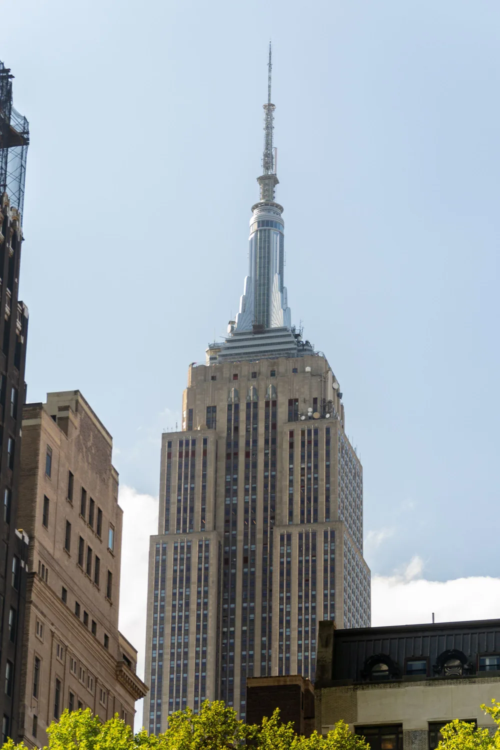 The Art Deco crown and spire of the Empire State Building against a clear blue sky