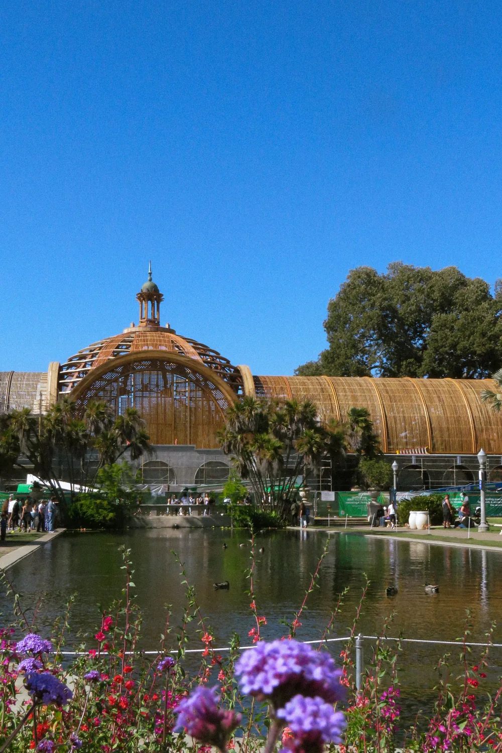 The Botanical Building at Balboa Park behind its lily pond, flowers in the foreground