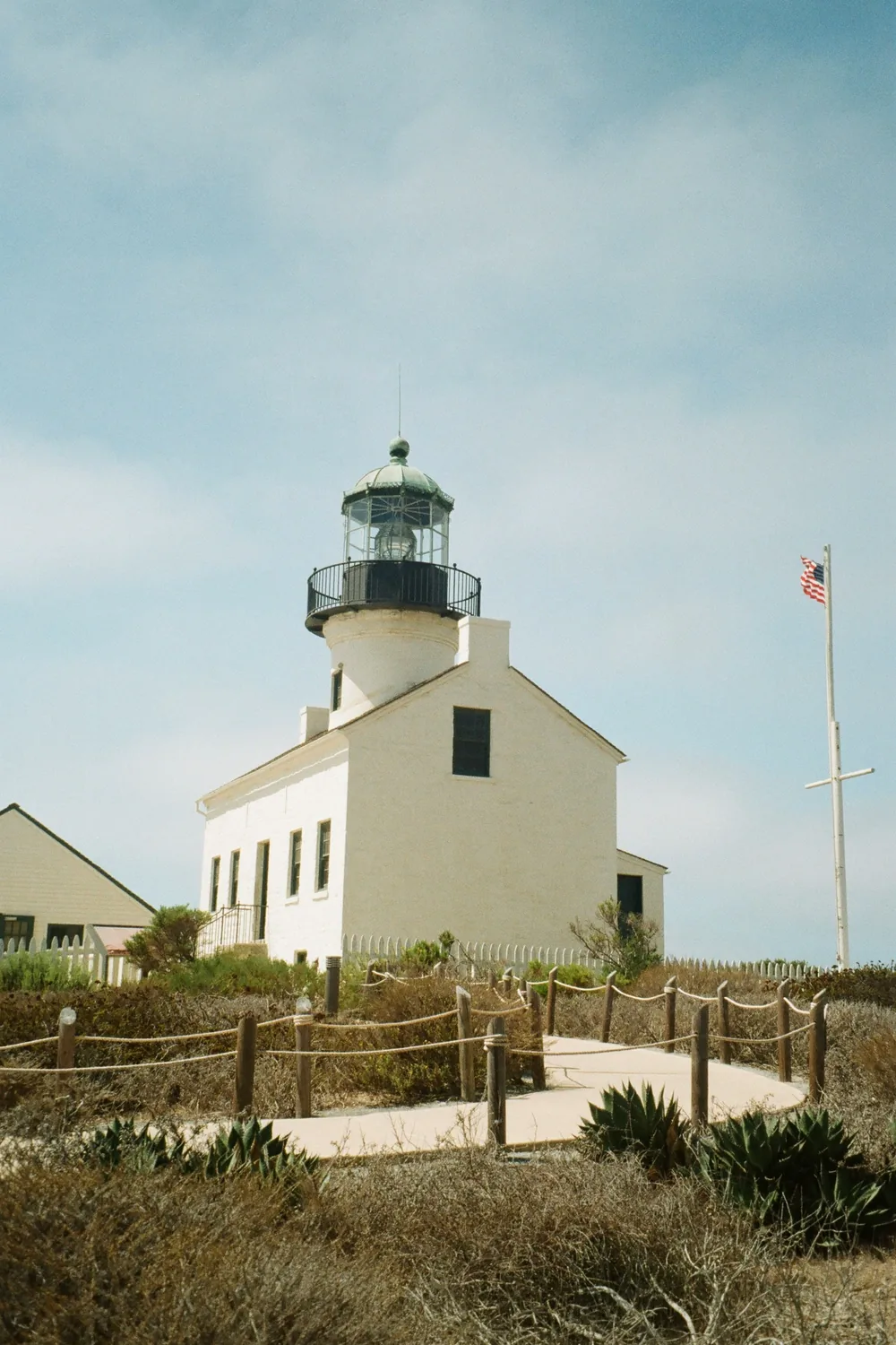 The Old Point Loma Lighthouse on its bluff above the sea, a flag flying beside it