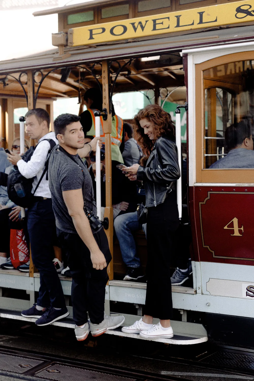 Passengers standing on the running board of a Powell Street cable car