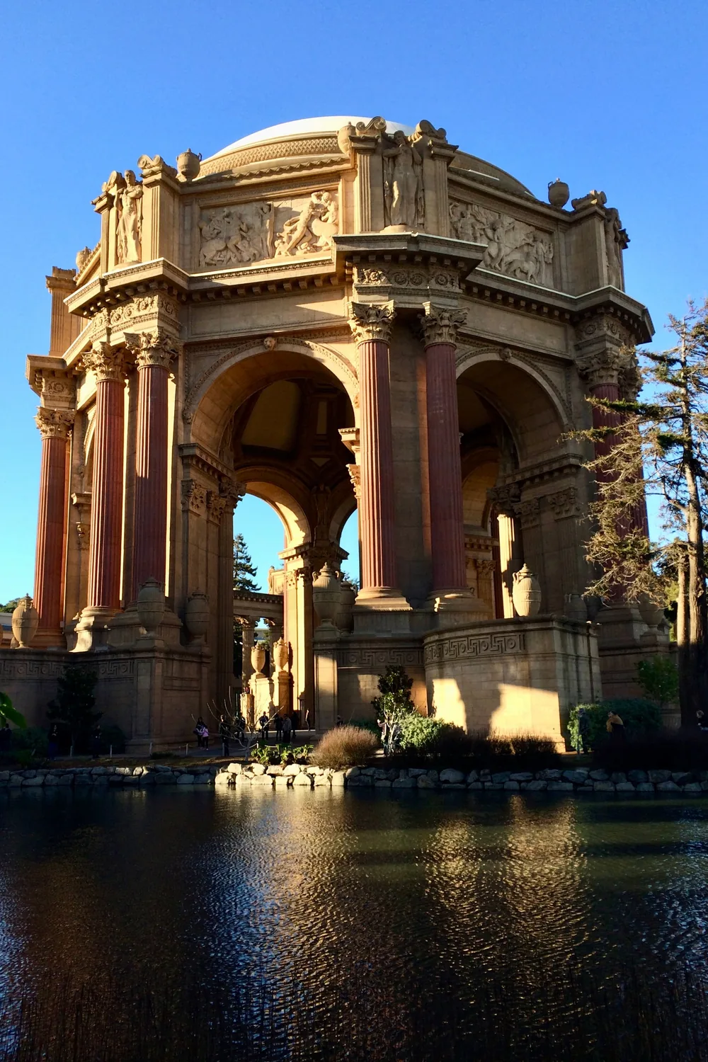 The rotunda of the Palace of Fine Arts in warm evening light, reflected in its lagoon