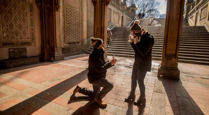 A man on one knee proposes under the arches of Bethesda Terrace in Central Park