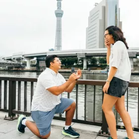 A proposal on a riverside walk in Tokyo, with the Tokyo Skytree behind the couple