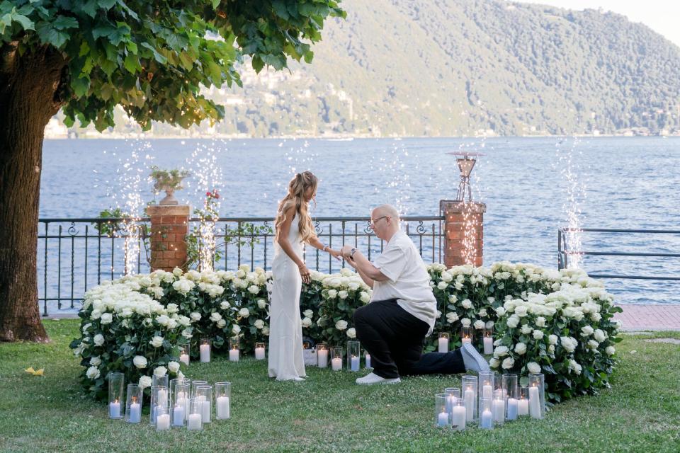 Elegant marriage proposal setup with white flowers overlooking Lake Como, Italy