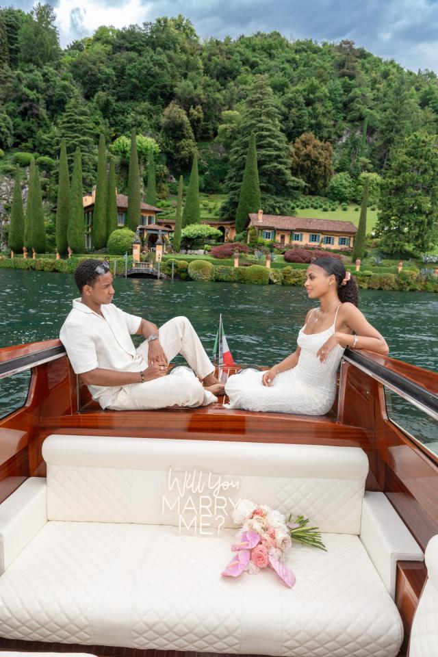 Newly engaged couple arriving by boat at Villa del Balbianello on Lake Como, Italy