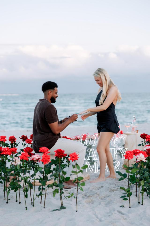 Man proposing among red and pink flowers on Miami Beach