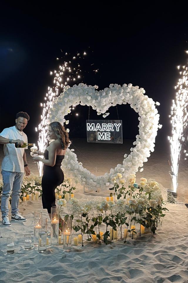 Nighttime Miami Beach proposal with cold sparks and a floral heart arch