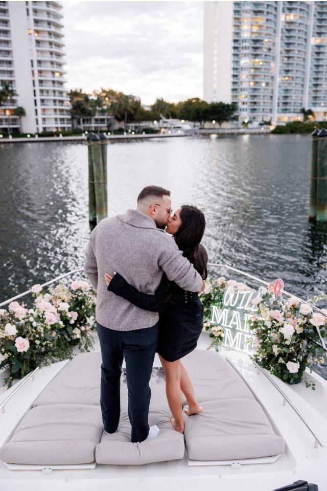 Couple embracing on a flower-decorated heart-shaped pier in Miami