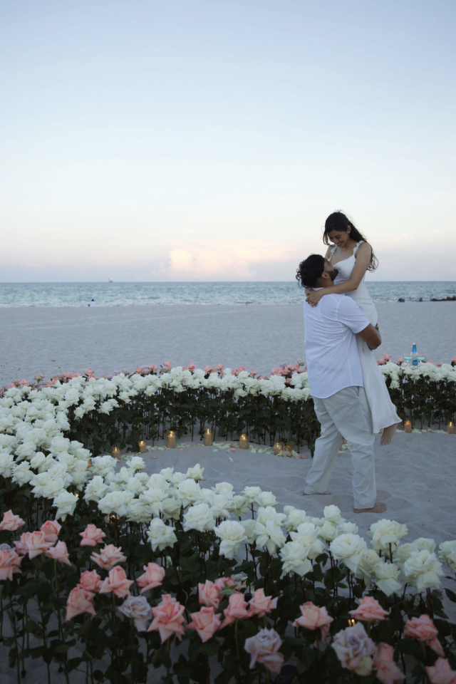 Couple embracing inside a pink and white floral heart on Miami Beach