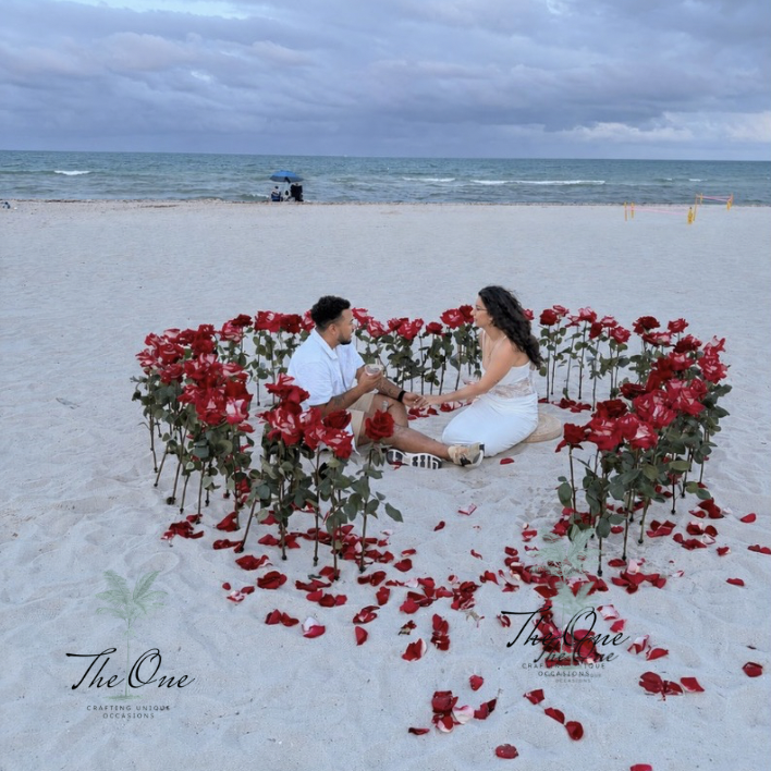 Couple inside a red rose heart proposal setup on Miami Beach